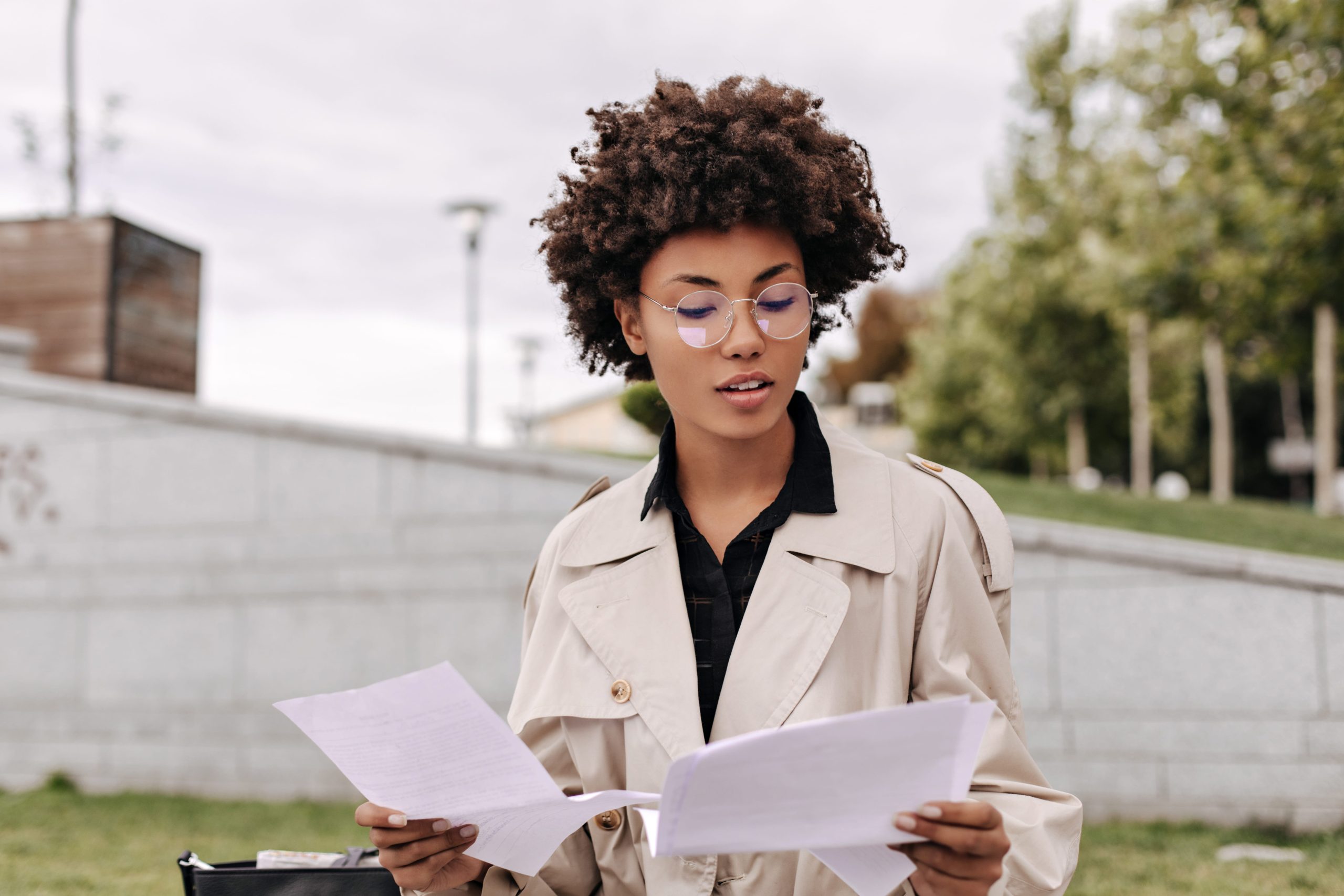 Focused woman reading documents outdoors