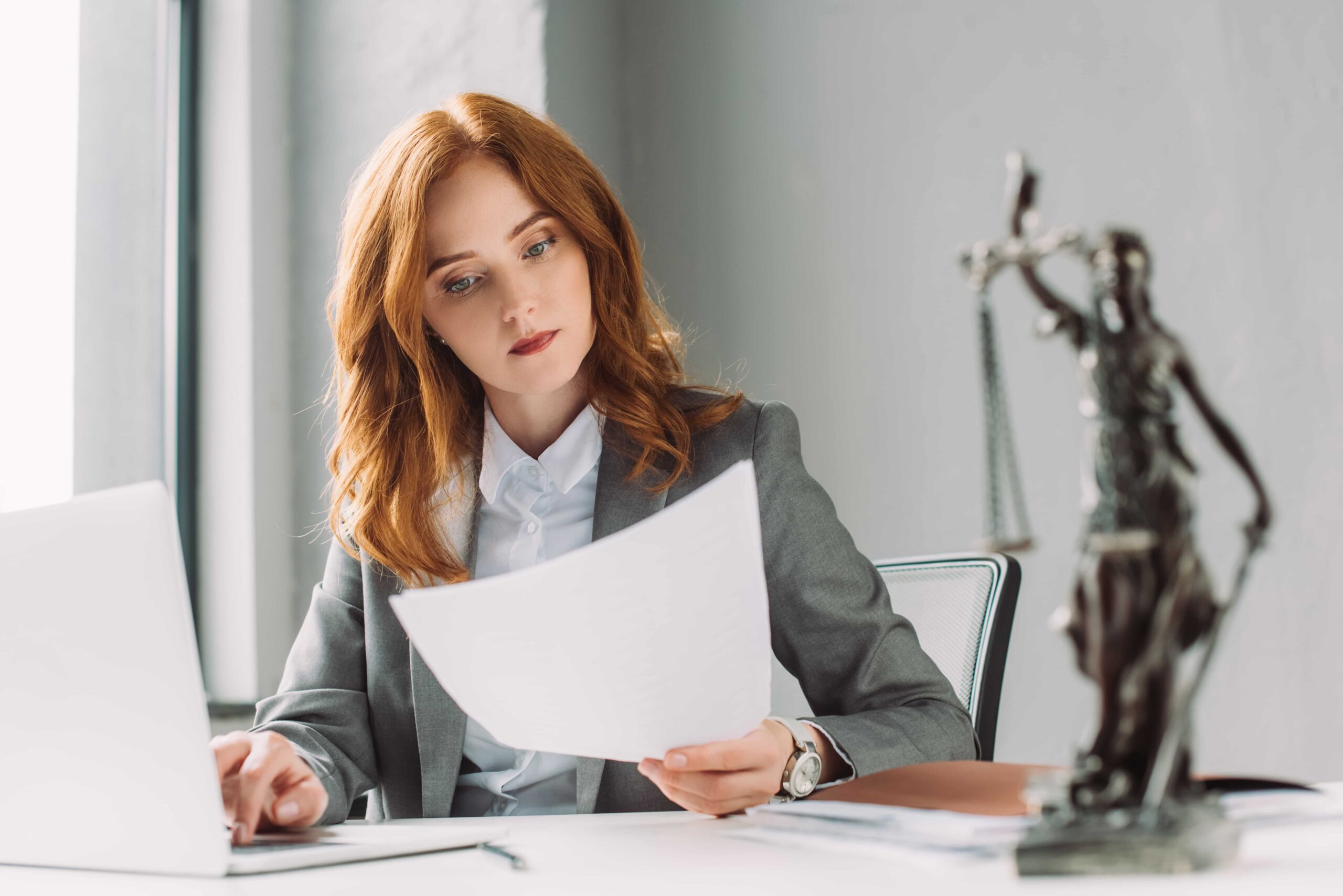 Professional woman reviewing legal documents at an office desk
