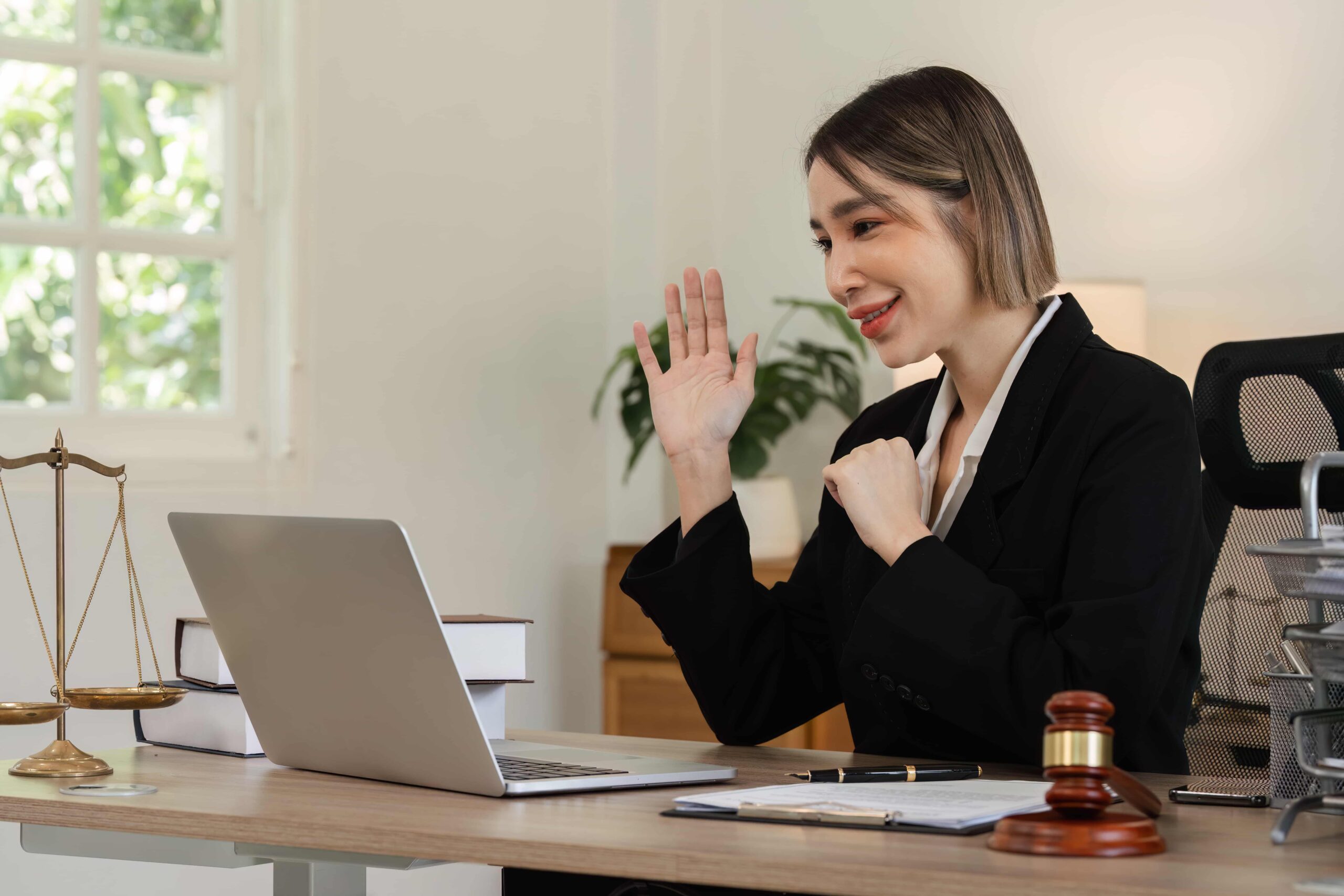 Professional woman waving during a virtual meeting